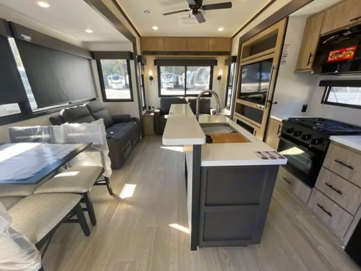 Spacious travel trailer RV rental interior. Features kitchen island, dining, sofa, and modern finishes. Perfect for adventures.. FOREST RIVER Campsite Elite 36RF 2026