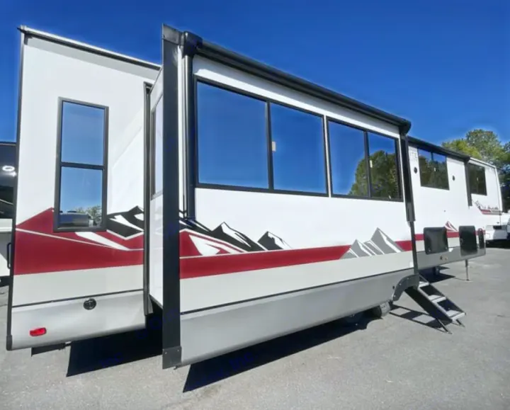 Experience adventure with this spacious white RV rental, featuring a red and grey mountain graphic, tinted windows, and an extended slide-out.. FOREST RIVER Campsite Elite 36RF 2026