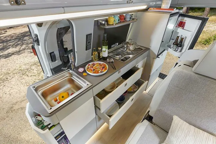 Compact rv rental kitchen: sink, stove, fridge, and organized drawers for all your road trip cooking needs.. Westfalia Kelsey 2024