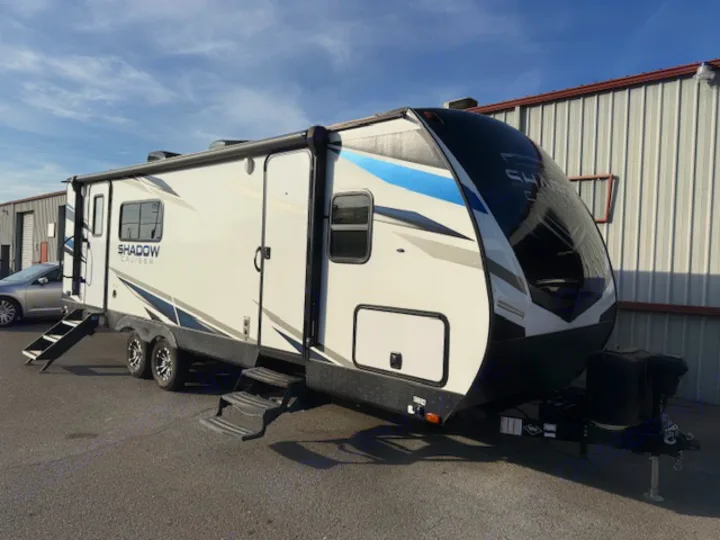This white Shadow Cruiser travel trailer with blue accents, steps extended, is ready for an RV rental adventure.. Cruiser RV Shadow Cruiser 248RKS 2022