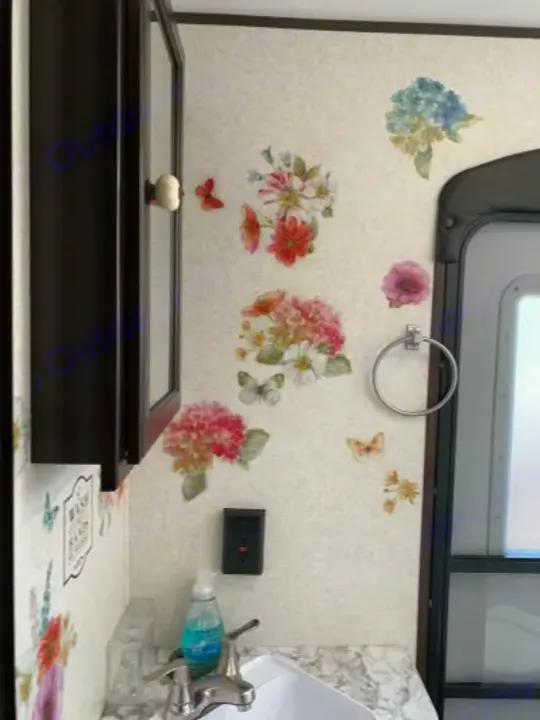 Charming RV rental bathroom with floral and butterfly wall decals, a sink, and dark cabinet.. Jayco Jay Flight SLX Baja Edition 2018