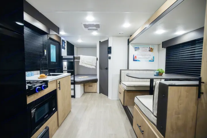 Spacious RV rental interior featuring a modern kitchenette, comfortable bunk beds, and a cozy dinette.. Forest River Campsite Reserve 17LS 2026