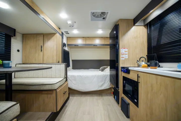 Modern RV rental interior with a cozy bed, dinette, and full kitchen, perfect for travel adventures.. Forest River Campsite Reserve 17LS 2026