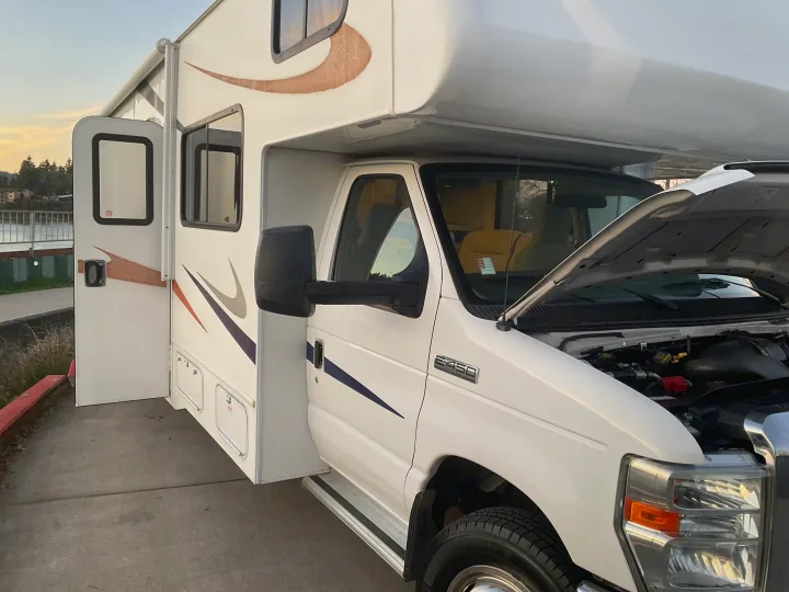 White Ford E-450 RV rental, hood open for inspection. This motorhome is being prepared for its next adventure.. Forest River Sunseeker 2014