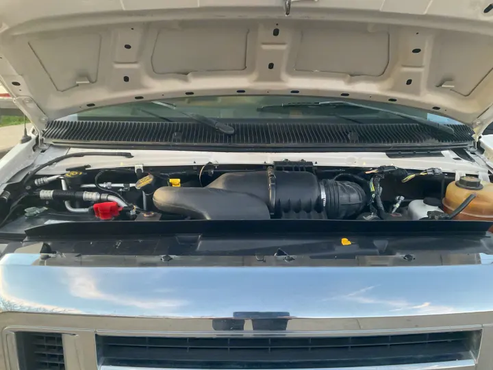 Open hood of an RV rental van, revealing the engine, air intake system, and fluid levels for pre-rental checks.. Forest River Sunseeker 2014