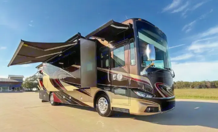 Luxurious dark-toned RV rental motorhome, with awnings extended, perfect for your ultimate road trip adventure.. Tiffin Phaeton 36 QHS 2015