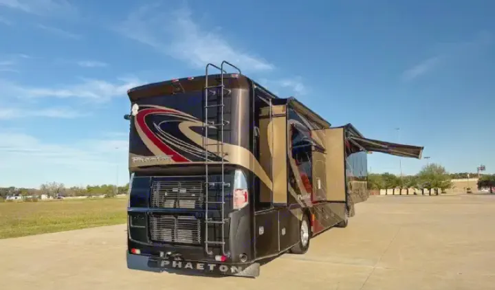 This luxury Phaeton motorhome, with its striking black, gold, and red design, is perfect for an rv rental, featuring extended slides and awning.. Tiffin Phaeton 36 QHS 2015