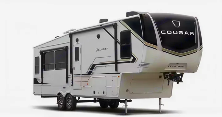 This white Cougar Keystone fifth-wheel RV, ideal for rv rental, features a modern design, multiple windows, and front hitch.. Keystone RV Cougar 2022