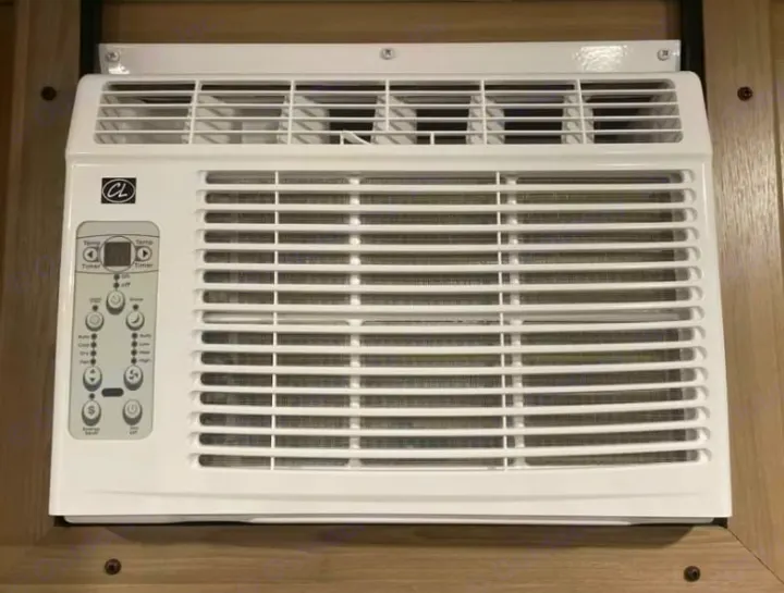 White AC unit in an RV rental, featuring a control panel for temperature, timer, and mode adjustments, ensuring indoor comfort.. Keystone RV Coleman 2025