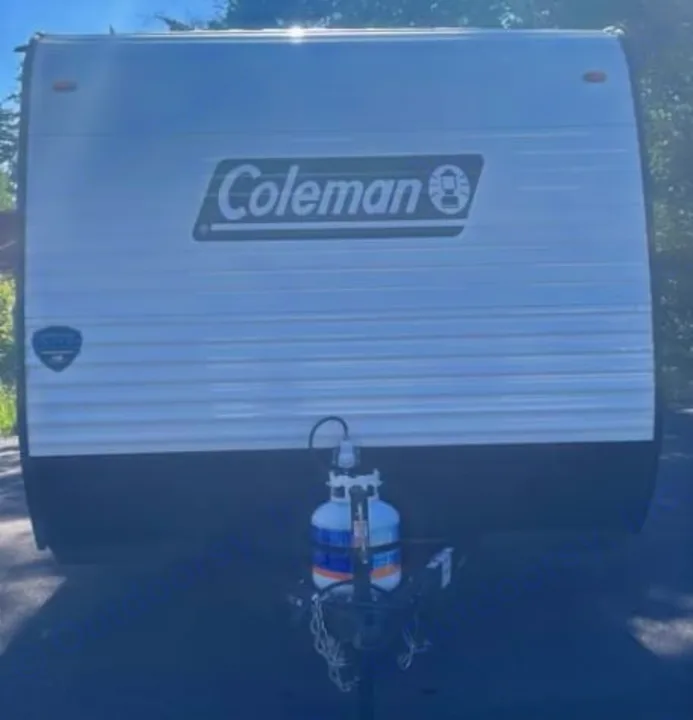 Front of a white Coleman travel trailer with propane tanks. This **rv rental** is ready for adventure.. Keystone RV Coleman 2025