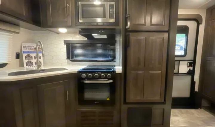 This RV rental offers a well-equipped kitchen with a sink, stove, oven, microwave, and fridge for your travels.. Keystone RV Flagstaff Super Lite 2023