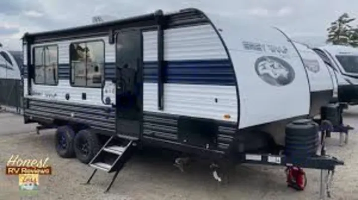 A modern white & dark gray travel trailer, branded "Grey Wolf," with steps extended. Perfect for an rv rental or camping trip.. Forest River Cherokee Grey Wolf 2025