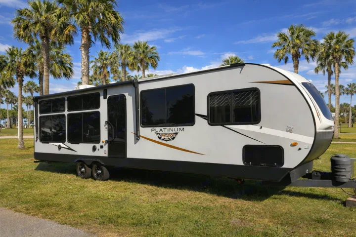 RV rental: Spacious Wildwood Platinum travel trailer parked under sunny skies with palm trees.. Forest River Wildwood FSX Platinum 2023