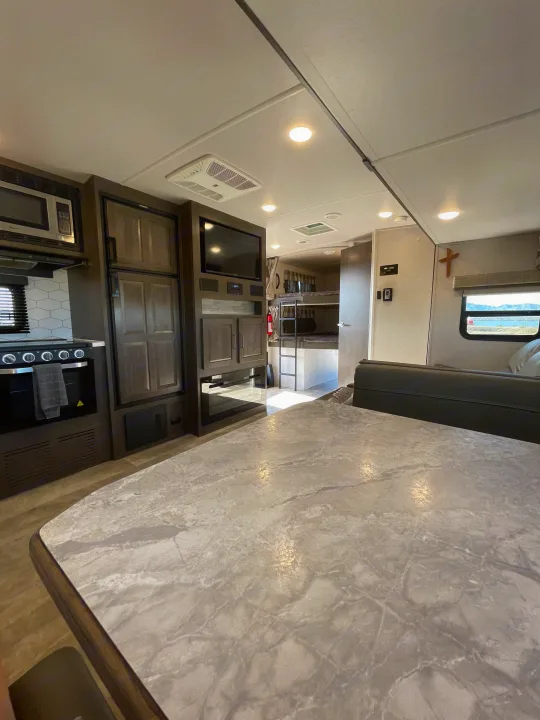 Spacious, modern RV rental interior featuring a kitchen, dining area, bunk beds, and a cozy living space.. Forest River Flagstaff Super Lite 2021