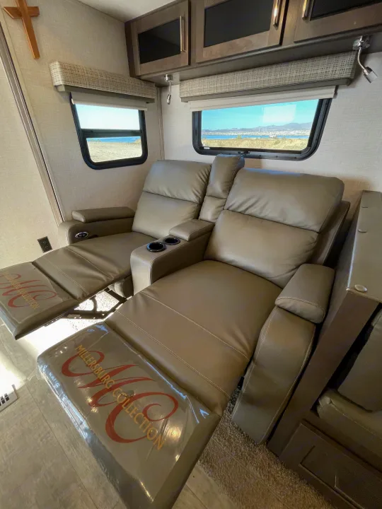 RV rental's cozy interior: two beige recliners with cup holders, extended footrests (Millersburg Collection), scenic window views.. Forest River Flagstaff Super Lite 2021