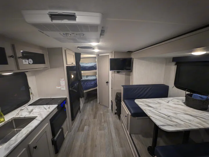 This rv rental offers a well-equipped kitchen, dinette, mounted TV, and bunk beds, perfect for family travel.. Coachmen Apex Nano 2025