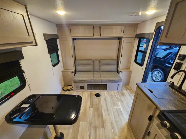 Spacious rv rental interior featuring a kitchen, dining table, and convertible sofa bed. Bright and modern camper design.. Forest River Viking 4K 2023