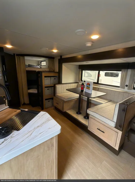 Interior of an rv rental, showing a kitchen counter, cozy dinette, and bunk beds with ample storage.. Forest River Cherokee Grey Wolf 2026