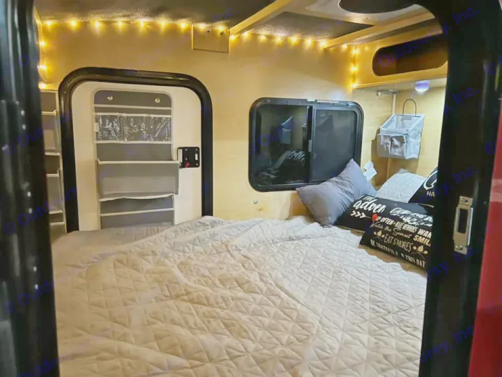Cozy RV rental interior with a comfortable bed, string lights, and clever storage solutions for your next adventure.. Outbound Trailer Outbound Extreme 2026