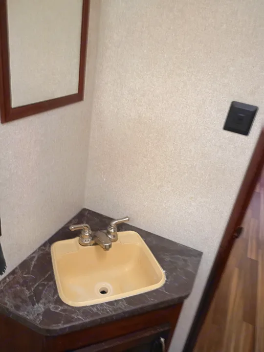 Compact RV rental bathroom: a beige sink on a marbled counter, framed mirror, and textured walls. Ready for your travels.. Jayco Jay Flight SLX 2017