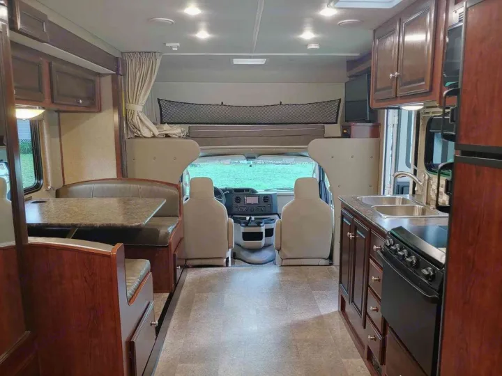 This RV rental interior features a kitchen, dinette, driver's cabin, and overhead bed, offering comfort and convenience.. Holiday Rambler Altera 2018