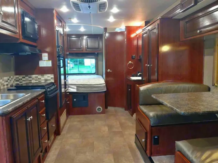 Spacious RV rental interior featuring a functional kitchen, comfortable bedroom, and a cozy dinette area.. Holiday Rambler Altera 2018