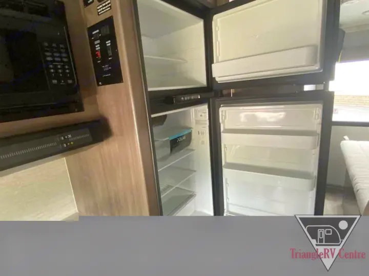 RV rental kitchen amenities: open fridge, freezer, microwave & control panel. All you need for your adventure.. Winnebago Spirit R24742 2025