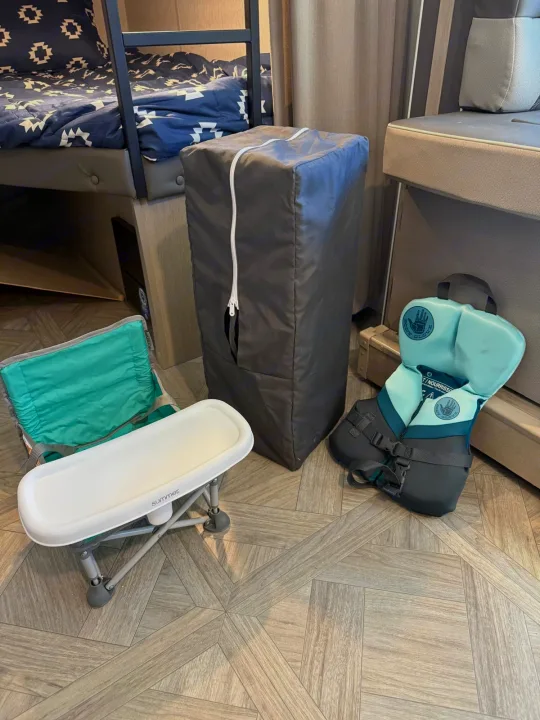 RV rental showing baby gear: portable high chair, travel crib, and child's life vest on wood-look floor.. Forest River Salem Cruise Lite Platinum 2023