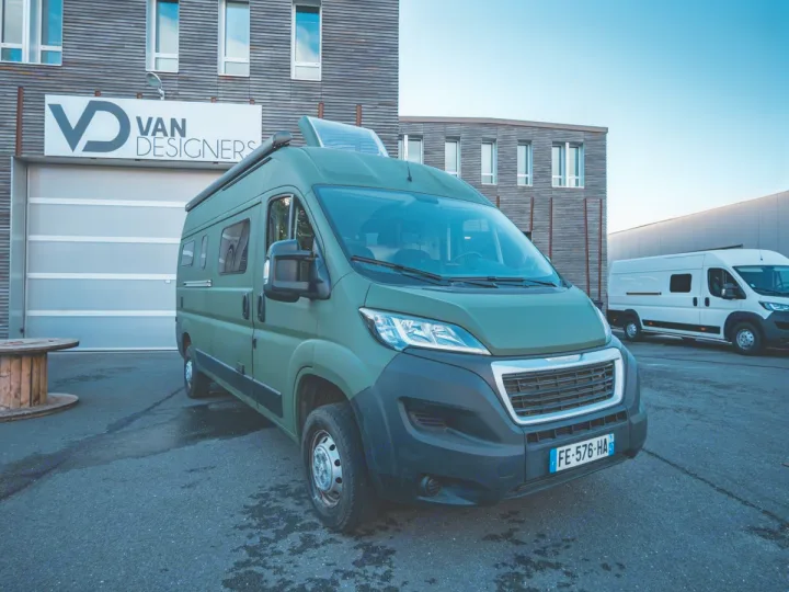 A sleek green custom camper van, potentially for rv rental, parked at Van Designers. Its pop-top roof hints at adventure.. Peugeot Boxer 2019