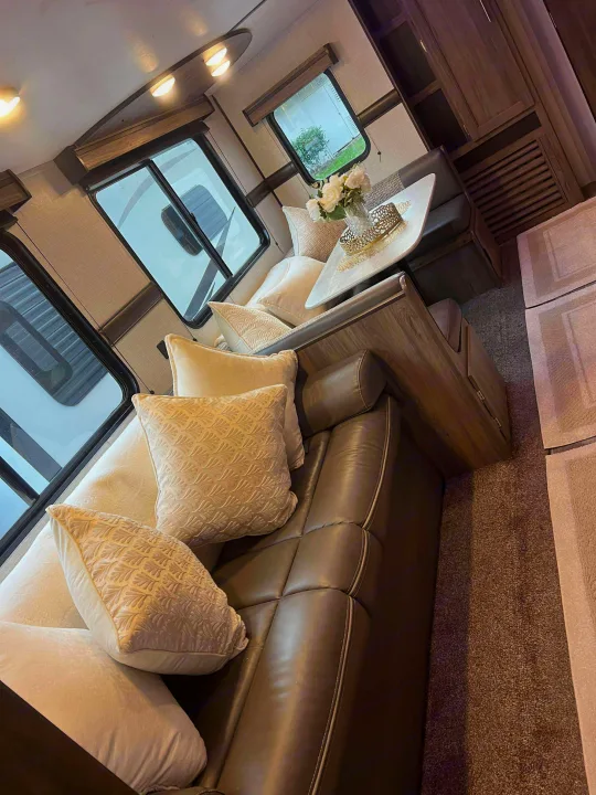 Cozy RV rental interior with a comfy sofa, dining nook, windows, and bright lighting for a welcoming space.. Crossroads RV Zinger 2024