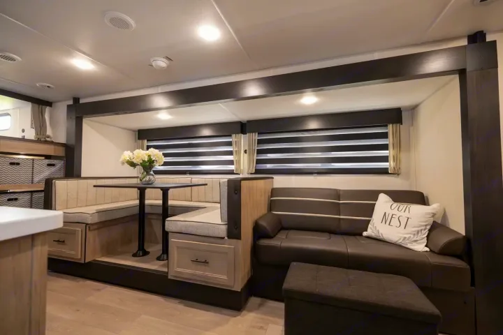 Enjoy this modern RV rental's cozy interior with a U-shaped dining booth, sofa, and convenient storage.. Forest River Cherokee Grey Wolf 2025