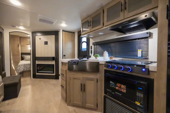 Explore this modern RV rental featuring a sleek kitchen with appliances, a cozy bedroom, and an electric fireplace.. Forest River Cherokee Grey Wolf 2025