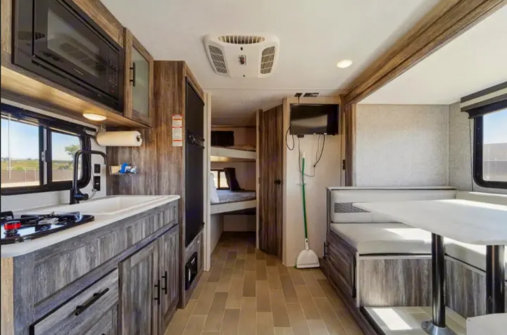 Spacious RV rental interior with a full kitchen, dinette, and bunk beds. Perfect for comfortable family adventures.. Forest River Salem FSX 2021