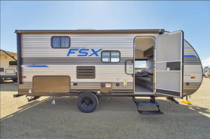 Side view of a Salem FSX travel trailer with striped exterior, door open & steps extended. Great option for rv rental & camping.. Forest River Salem FSX 2021