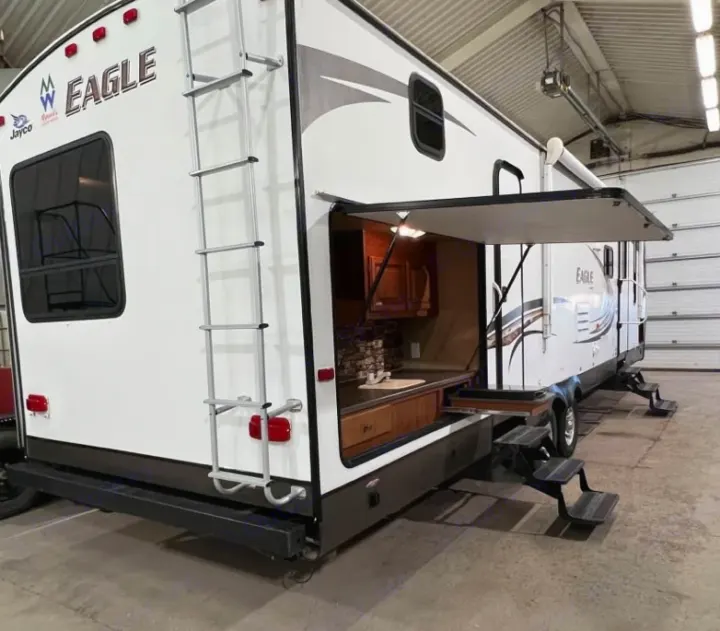 This Jayco Eagle RV rental showcases a unique outdoor kitchen, ladder, and convenient steps, ideal for travel adventures.. Jayco Eagle 2014
