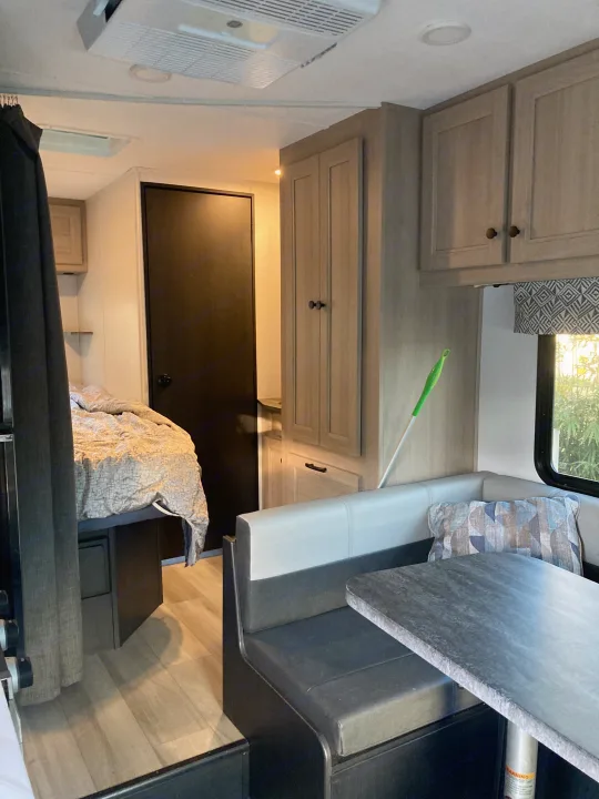 Inside an RV rental: compact living space with a comfy bed, dinette, and storage cabinets for your travels.. Forester LE 2024