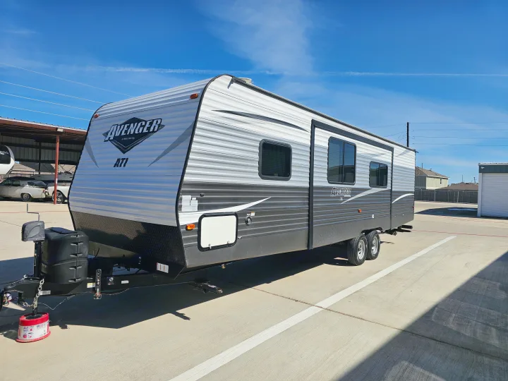 Avenger ATI travel trailer RV rental, parked outdoors under a blue sky. Perfect for your next camping adventure.. Avenger ATI 2019