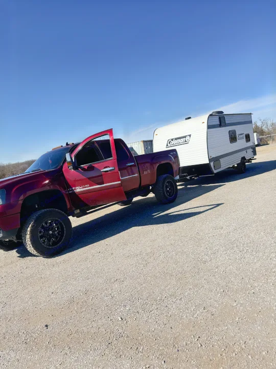 GMC Denali HD pickup truck towing a white Coleman RV, ready for an rv rental trip.. Keystone RV Coleman 2025