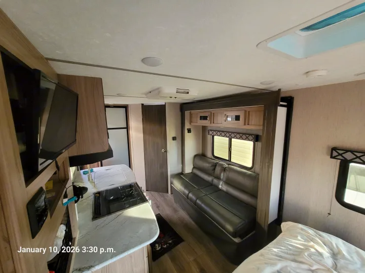 Interior of an **rv rental** showcasing a kitchen, living area with sofa, TV, and bed. Provides a clear view of the cozy living space.. Coachmen Freedom Express 192RBS 2021
