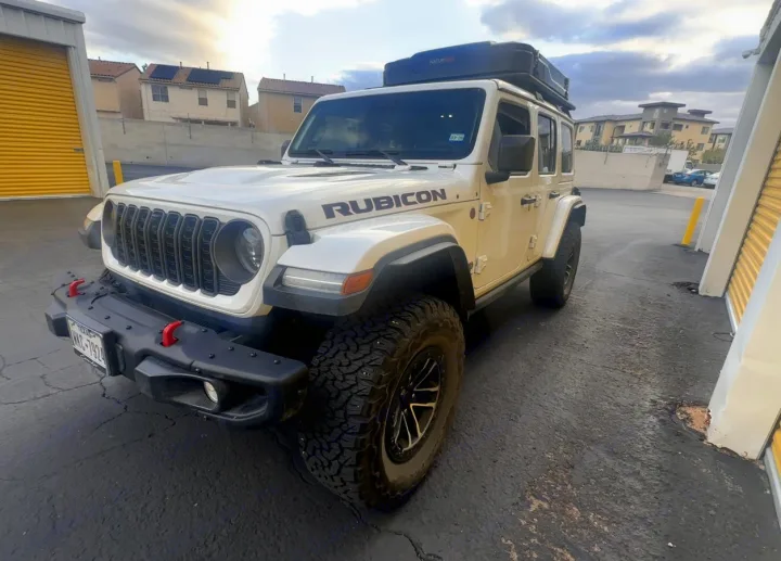Experience adventure with this white Jeep Rubicon featuring a rooftop tent, a rugged option for your next RV rental.. Jeep Wrangler Rubicon X 2024