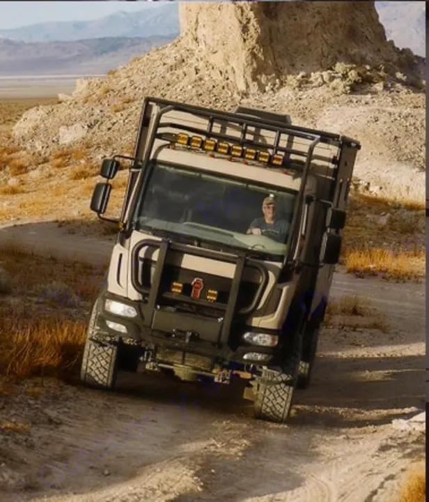 Rugged off-road RV rental, an expedition truck camper, navigating a dusty desert trail. Perfect for adventure.. Storyteller Epic 2025