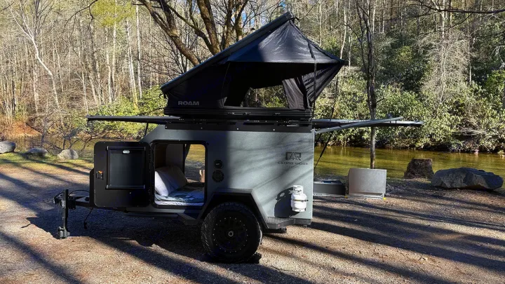 Compact Cedar Ridge Campers rv rental with a deployed ROAM rooftop tent by a serene river, perfect for outdoor adventure.. Cedar Ridge Deneb XT 2025