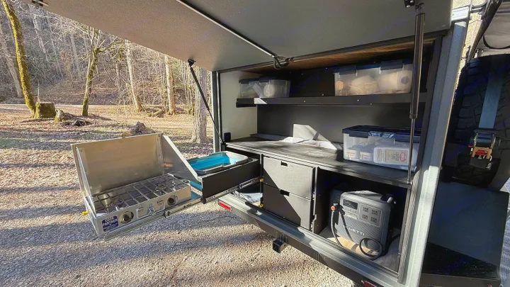 RV rental camp kitchen: pull-out stove, sink, organized storage, and BLUETTI power station for outdoor cooking & adventure.. Cedar Ridge Deneb XT 2025