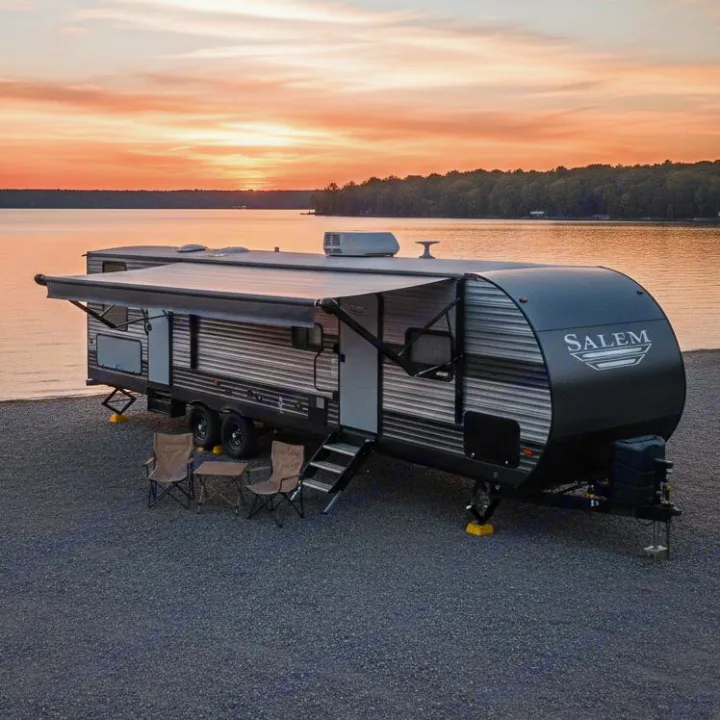 Experience nature with this Salem RV rental, parked on a gravel shore by a serene lake at sunset, awning extended for comfort.. Forest River Salem 2019