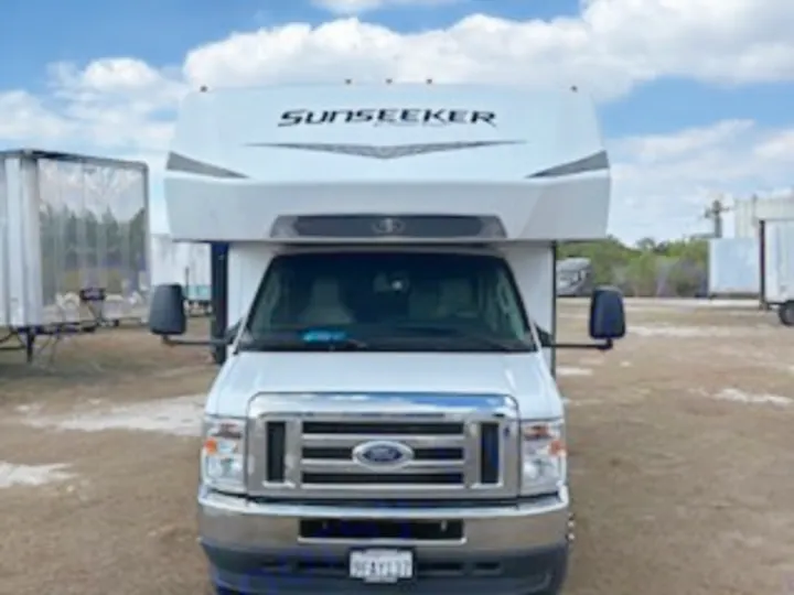 Frontal view of a white Ford Sunseeker Class C RV rental, parked outdoors. Perfect for your next road trip or camping adventure.. Forest River Sunseeker LE 2024