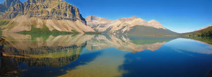 Panoramic mountain lake reflections. Imagine this stunning view on your RV rental journey, exploring serene nature.. Toyota HIACE CAMPERVAN 2009