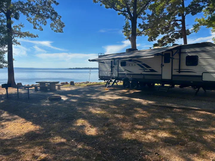 Relax with a waterfront RV rental! This PUMA travel trailer offers lake views, a picnic table, and a fire pit for camping.. Forest River Palomino Puma 2021