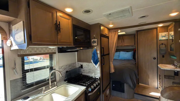 Modern RV rental interior with a bright kitchen, cozy bedroom, and compact bathroom vanity. Ready for your travels!. Coachmen Other 2020