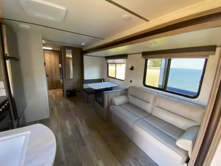 Cozy rv rental interior: spacious living area with couch, dinette, and modern kitchen. Perfect for travel!. Gulf Stream Ameri-Lite 2023