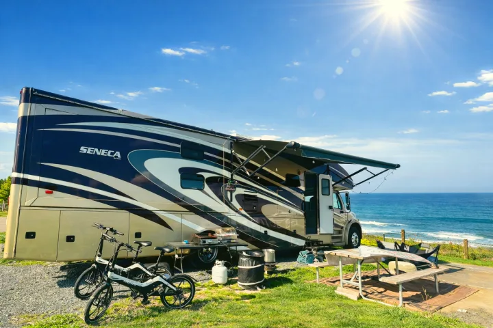 Jayco Seneca RV rental with bikes parked oceanfront under sunny skies, ideal for outdoor camping.. Jayco Seneca 2013